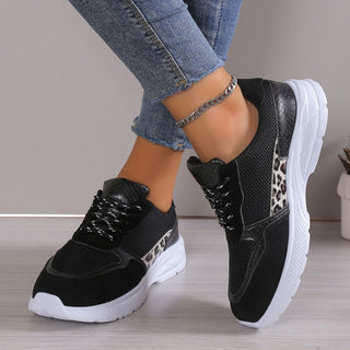 Stylish women's black and white sneakers with leopard print accents, featuring a comfortable and trendy design for casual wear.