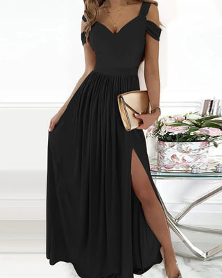 Elegant black maxi dress with off-the-shoulder design, sweetheart neckline, and high slit accent, displayed on a white background with floral arrangements in the foreground.