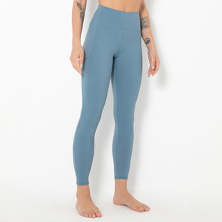 Stylish blue athletic leggings on display. The image shows a woman's lower body wearing comfortable, high-waisted yoga pants with a flattering fit. These sleek, modern sportswear bottoms are designed for active lifestyles and physical fitness activities.