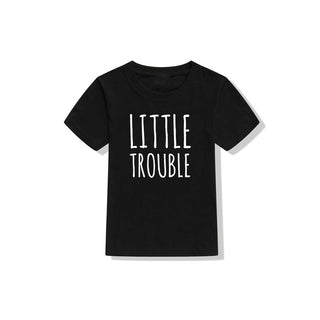 Matching black T-shirts with "Little Trouble" text printed in white. Stylish graphic design on a basic apparel item, perfect for casual wear.