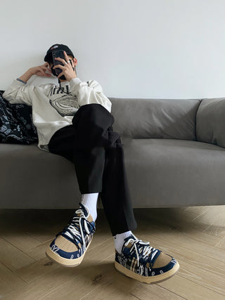 Stylish fitness sneakers with bold zebra print design on a person relaxing on a grey sofa