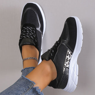 Modern women's black and white mesh sneakers with lace-up closure, showcasing a breathable and lightweight design for casual or athletic wear.