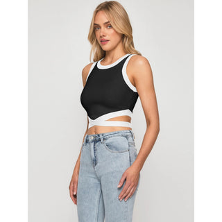 Cropped sleeveless black and white color block activewear top featured on young, fit female model against white background.
