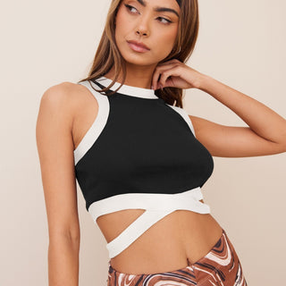 Sleek black and white cropped top with contrasting design, worn by a young woman with a thoughtful expression.