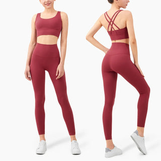 Vibrant fitness leggings and sports bra set in burgundy red, featuring a crossover back design for an active, stylish look.