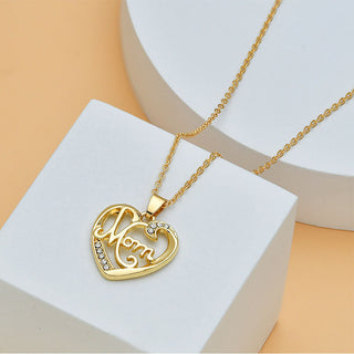 Gold-toned heart-shaped necklace with the word "Mom" and diamond accents, displayed on a white background.