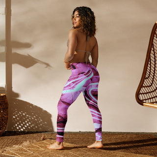 Vibrant purple yoga leggings with modern abstract design, worn by a young woman with curly hair against a light-colored backdrop and woven furniture.