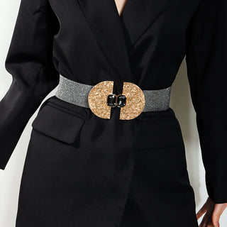 Stylish black dress with a decorative metallic waist belt featuring a large round gold buckle
