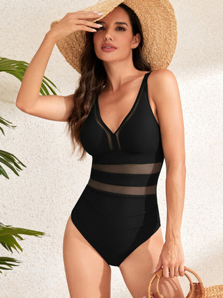 Stylish black one-piece swimsuit with mesh panel accents, perfect for a chic beach look.