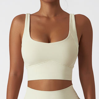Ivory-colored sports bra with wide straps, designed for active wear and fitness activities.