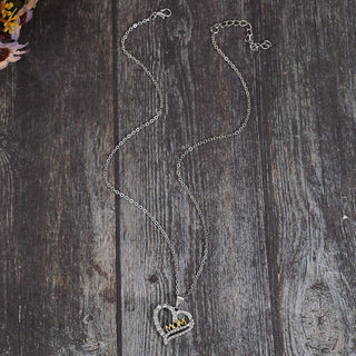 Elegant Crystal Heart Pendant Necklace on a rustic wooden background