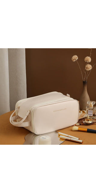 Elegant white leather cosmetic bag with double zipper design and ample storage space for skin care products, displayed on a wooden table with floral decor.