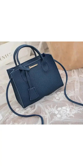 Elegant navy blue leather satchel with gold-toned hardware. Stylish and versatile one-shoulder handbag with a structured silhouette, perfect for carrying a mobile phone and other essentials.